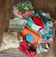Pile of assorted vintage fabrics and trims on floor