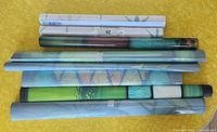 Seven rolled items: five window films and two shelf liner rolls