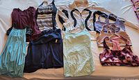 Overview of nine garments laid out on bed