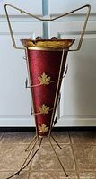 Full view of ashtray stand showing red fiberglass cone, maple leaf appliqués, metal frame, glass ashtray, handle, and cord