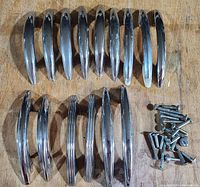 All drawer pulls and screws laid out on wooden surface