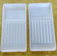 Front view of two milk glass trays showing smooth and ribbed sections