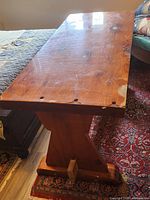 angled view of trestle table top showing lacquer loss and pedestal support