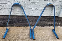 Both blue metal ladder stabilizers side by side against wall