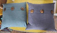 Front view of both cushions showing buttons and colors