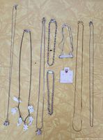 All chains, bracelets and ruby stud laid out for overview
