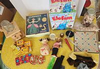 Overall view of lot on yellow table showing games, toys, candies, streamers and Scrabble items