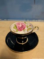 Teacup on saucer, showing floral interior, gold trim, cobalt exterior