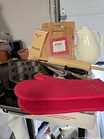 Entire lot grouped together showing boards, pan, mitt, pitcher, rolling pin and knives