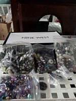 Multiple bags of assorted beads with cabochon in front