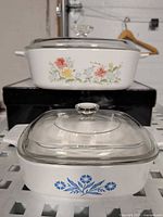 Front view of both casseroles with lids showing floral patterns