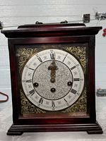 Front view of Kienzle wooden mantel clock showing dial and case