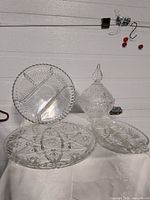All clear glass items grouped: candy dish, two trays, small dish