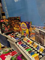 Clue, Cranium, small Blokus box, 1000-piece puzzle, trays of acrylic paint tubes visible