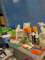 Overall lot with boxed Swiffer refills, various cleaners, aerosols, sponge, cloths and pods on plastic bin