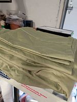 Folded sage green king sheet set on table