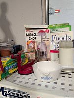 Group shot showing Miracle Chop box, apple peeler, ceramic bowl, Press’n Seal wrap, Braun grinder, book, insulation kit