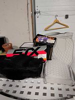 Overview of lacrosse protective gear including STX Fusion arm guards, white padded protector and unopened accessory