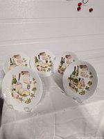 Front view of five Limoges plates displaying still-life design