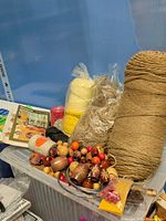 Overview of bin with cords, beads and book