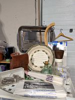 Group showing roasting pan, plate, glassware, candles, leather pouch, utensils and chamois cloth