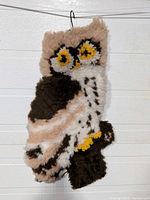 Full view of hooked rug owl wall hanging suspended from hanger