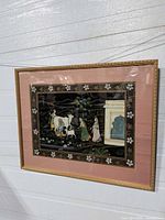 Full view of framed cloth painting with figures, mat and frame visible