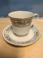 Cup on saucer showing floral band and gold trim