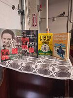 Front view of all four books standing on lace-covered surface