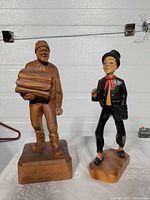 Front view of two wooden statues showing details and relative sizes