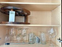Overview of lot: wooden wine rack, wine glasses, beer mugs, chiller stick, mesh infuser