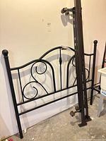 Front view of black metal headboard leaning against wall