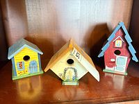 All three painted wooden birdhouses side by side