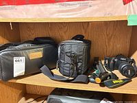 Entire lot on shelf: camera, two bags, tripod