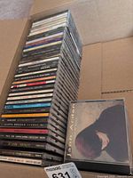 Stack of approximately 45 CDs in box, Jann Arden disc on top