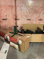 Both cardboard boxes with tree parts visible, metal stand on top