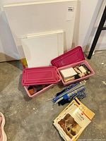 group shot showing canvases, bins, knitting needles and booklets