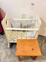 White painted doll crib and small pine stool full view