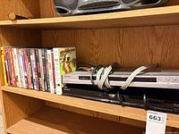 Shelf with Sony DVD and Blu-ray players, stack of DVD movies