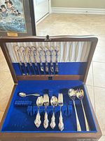 Open Birks chest showing knives in lid, assorted flatware and servers in base