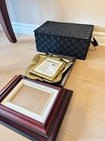 Basket and stack of assorted frames on floor