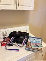 Washer top view of bags, books, strap and some golf items