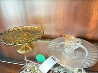 Amber glass pedestal cake stand and other items on shelf