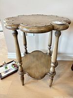 Full view of accent table showing floral top, legs, and shelf