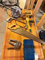 Overall lot on table: circular saw, hand saw, jigsaw, staple gun, socket set, clamp, jab saw