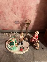 Entire ceramic caroler scene with base, lamp post, figures, reindeer and wreath