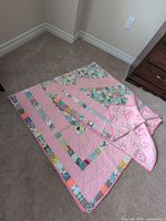 full view of quilt front showing pink borders and patchwork centre