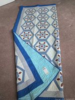 Full view of folded quilt showing pattern and borders