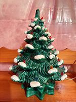 Front view of ceramic Christmas tree showing lights and snow accents