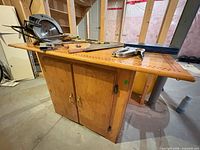 Front view of wood workbench showing top surface and cabinet doors